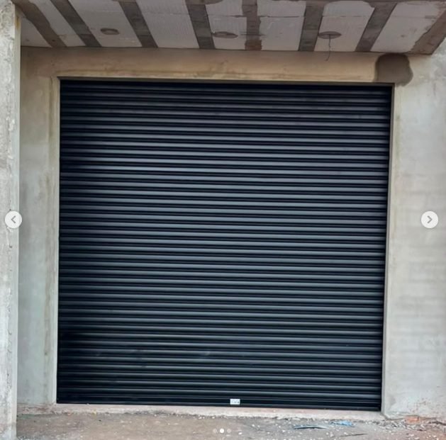 Porta de enrolar preta instalada em garagem